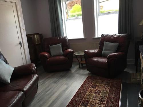 a living room with two leather chairs and a couch at Lily's in Manorhamilton