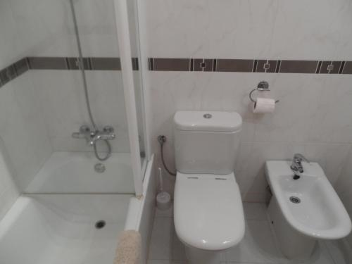 bagno bianco con servizi igienici e lavandino di Brijon apartment a Moraira
