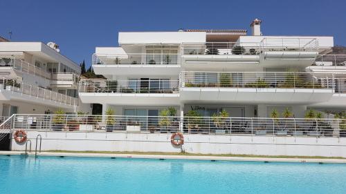 a building with a swimming pool in front of a building at PANORAMIC HOME in Benalmádena