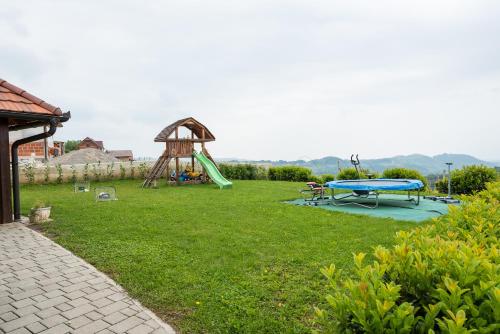 Wineyard getaway house في Sevnica: ساحة مع ملعب مع زحليقة وطاولة