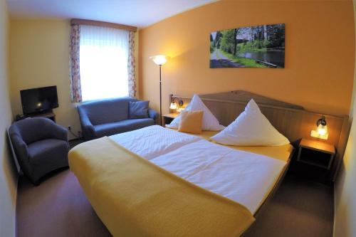 a hotel room with a bed and a chair at Hotel Drei Kronen in Frauenwald