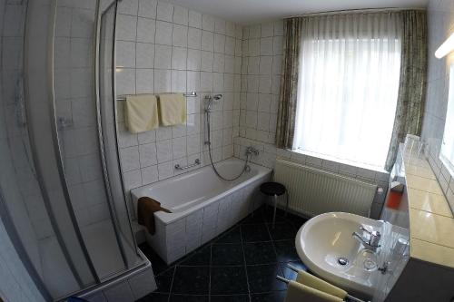 a bathroom with a bath tub and a sink at Hotel Drei Kronen in Frauenwald