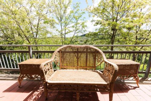a wicker chair and table on a balcony at Casa Ermo Colle in Sant'Ermo