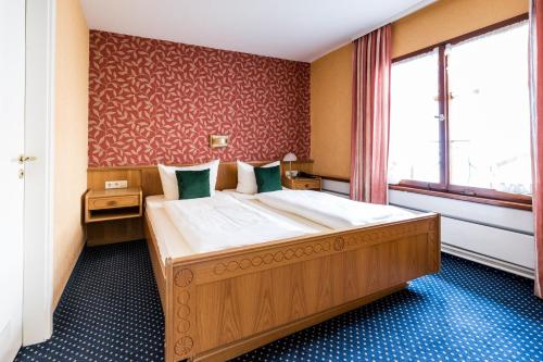 A bed or beds in a room at Hotel Löwen-Weinstube