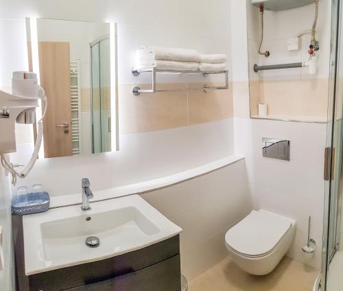 Apartment De Luna في براغ: حمام ابيض مع مرحاض ومغسلة