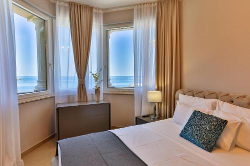 a bedroom with a large bed with two windows at Regina del Mare in Bar