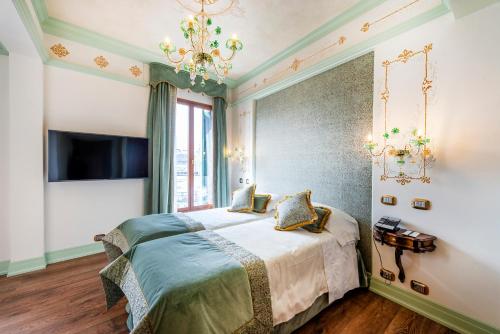 a bedroom with a bed and a chandelier at Monaco & Grand Canal in Venice
