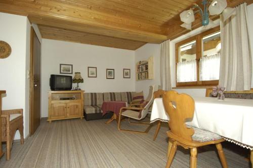 sala de estar con sofá y TV en Ferienwohnung Waldblick en Scheffau am Wilden Kaiser