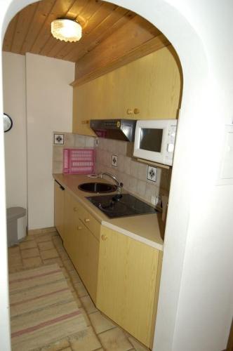 a small kitchen with a sink and a microwave at Ferienwohnung Waldblick in Scheffau am Wilden Kaiser