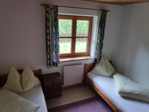 a small room with two beds and a window at Ferienwohnung Waldblick in Scheffau am Wilden Kaiser
