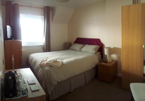 a hotel room with a bed and a window at Maggie's in Inveraray