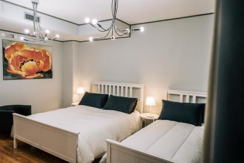 ein Schlafzimmer mit 2 Betten und einem Wandgemälde in der Unterkunft Le Finestre di Via Asiago in Catania