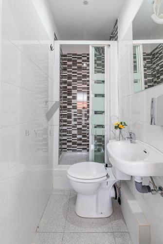 a white bathroom with a toilet and a sink at AYZ Sierra de Meira - Auto check-in property in Madrid