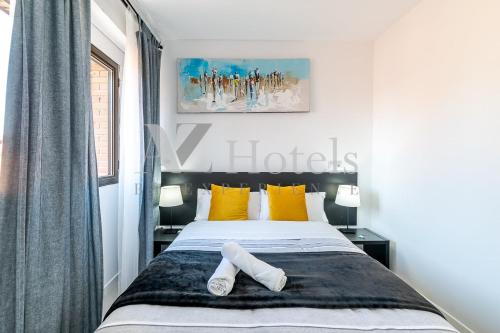 a bedroom with a bed with yellow pillows at AYZ Sierra de Meira - Auto check-in property in Madrid