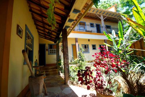 an outside view of a house with flowers and a porch at Arraial Velho Pousada Tematica in Tiradentes