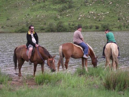 three people are riding horses in a river at MacFarlanes in Harrismith