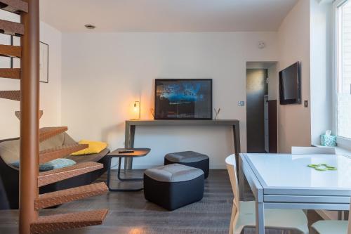 a living room with a staircase with a tv on the wall at LOFT AU COEUR DE LA VALLÉE DE LA LOIRE in Montlouis-sur-Loire