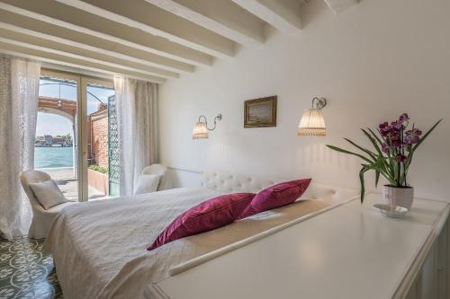 a white bedroom with a bed and a window at Ca' Dell'Ulivo Private Garden in Venice