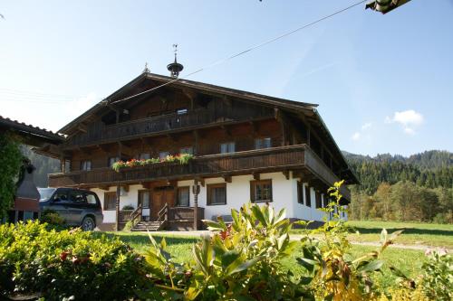 a large wooden house with a car parked in front at Schwaighof in Oberau