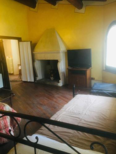 a bedroom with a fireplace and a bed and a tv at camere della vecchia posta in Trevi