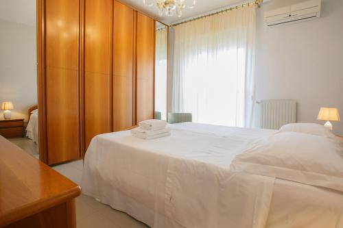 Un dormitorio con una gran cama blanca y una ventana en Ginevra Apartment, en Cefalú