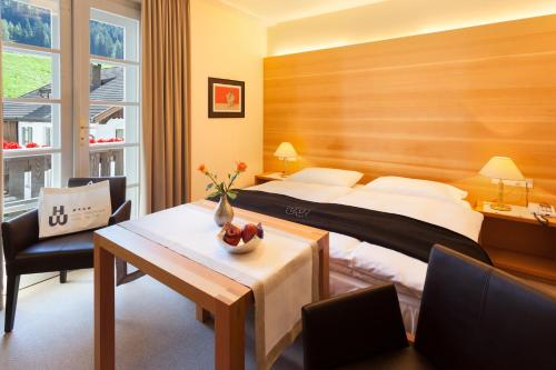 a hotel room with a bed and a table with a bowl of fruit at Hotel Tre Cime Sesto - Sexten in Sesto