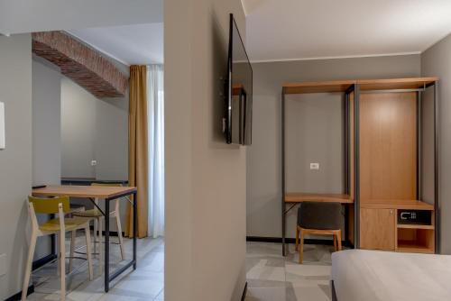 a room with a bed and a table and a dining room at APARTHOTEL CASA MIA in Milan