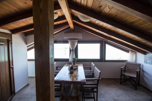 a dining room with a table and some windows at Golden Attic in Nea Roda