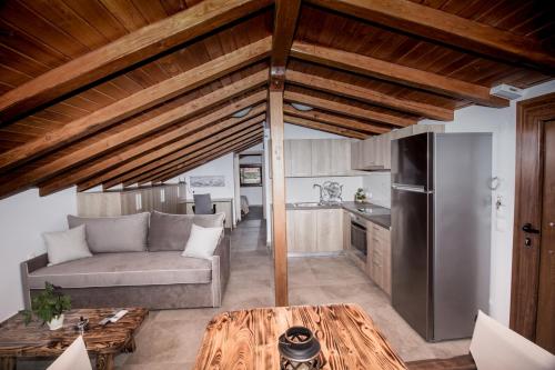 a living room with a couch and a kitchen at Golden Attic in Nea Roda