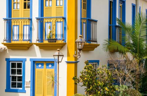 a building with blue and yellow windows and a street light at Arraial Velho Pousada Tematica in Tiradentes