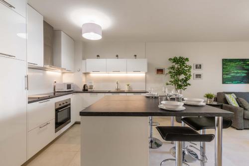 a kitchen with white cabinets and a black counter top at Appartement cathédrale au calme in Aix-en-Provence