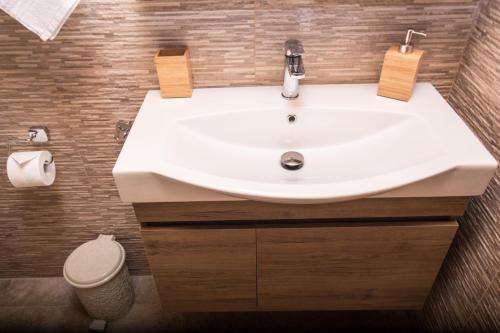 a bathroom with a white sink and a toilet at Golden Attic in Nea Roda