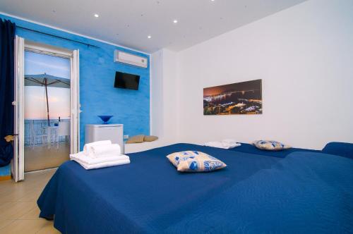 a blue bedroom with a blue bed with two pillows at Pensione Zio Attilio in Casal Velino
