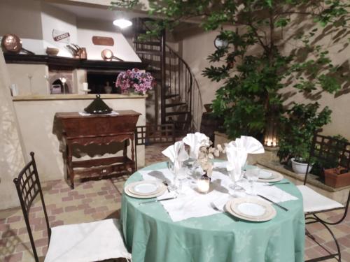 a table with a green table cloth on it with a staircase at Le Térébinthe B&B in Lauris