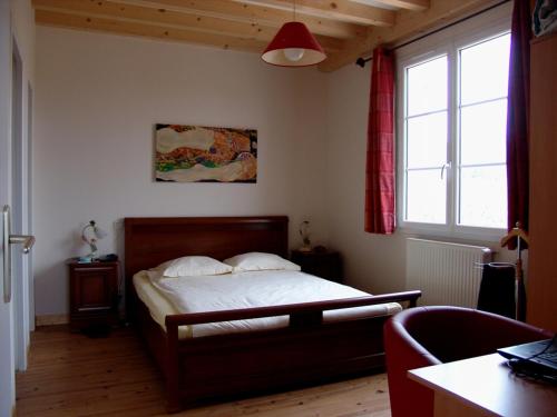 Schlafzimmer mit einem Bett, einem Schreibtisch und einem Fenster in der Unterkunft LA VIGNERAIE in Fuissé