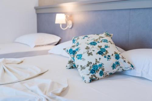Una cama con una almohada azul y blanca. en Guest House S-Lux en Petrovac na Moru