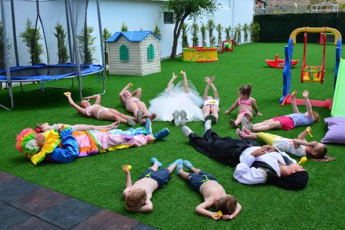 a group of children laying on the grass in a playground at Parkim Ayaz Hotel in Gümbet