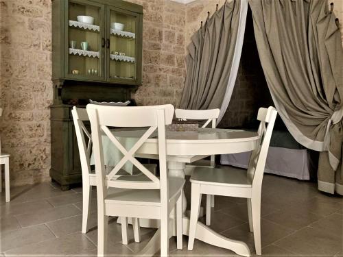 ein Esszimmer mit einem weißen Tisch und Stühlen in der Unterkunft Le Petunie in Ostuni