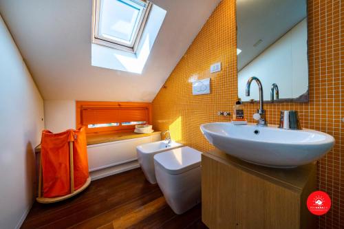a bathroom with a sink and a toilet and a skylight at La Casa dagli Occhi Blu in Portovenere
