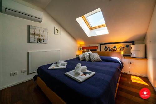 a bedroom with a bed with towels and a skylight at La Casa dagli Occhi Blu in Portovenere