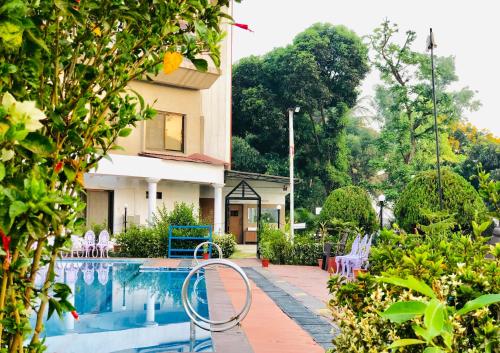 a swimming pool in front of a house at VITS Kamats Resort, Silvassa in Silvassa