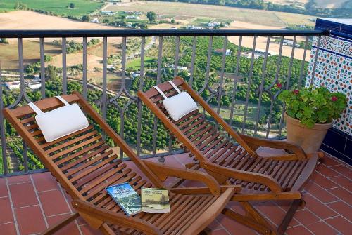 two chairs and a table on a balcony at Hotel El Convento in Arcos de la Frontera