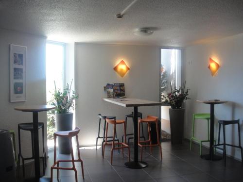 a room with two tables and chairs and lights at ibis budget Châtellerault Nord in Châtellerault