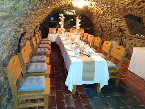 a long dining room with a long table and chairs at Penzión pod kláštorom in Pezinok