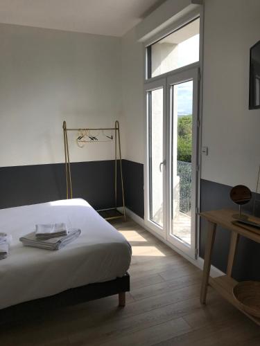 a bedroom with a bed and a sliding glass door at Domaine de Selhac in Frontignan