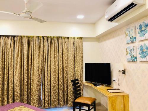 a room with a desk with a monitor and a chair at VITS Kamats Resort, Silvassa in Silvassa