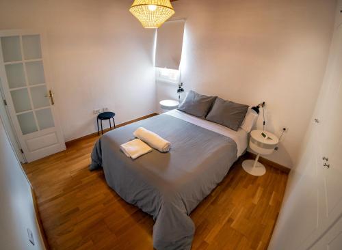una piccola camera con un grande letto e un lavandino di NEBRIJA a Santa Cruz de Tenerife