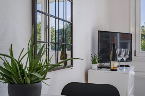 a living room with a plant and a tv at The Place-Studio in Schiltigheim