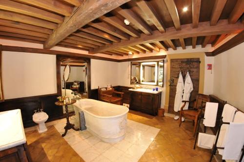 uma grande casa de banho com banheira e lavatório em Château de Bagnols em Bagnols