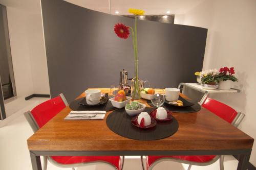 a wooden table with food on it with red chairs at Loft La Città Vecchia in Genova